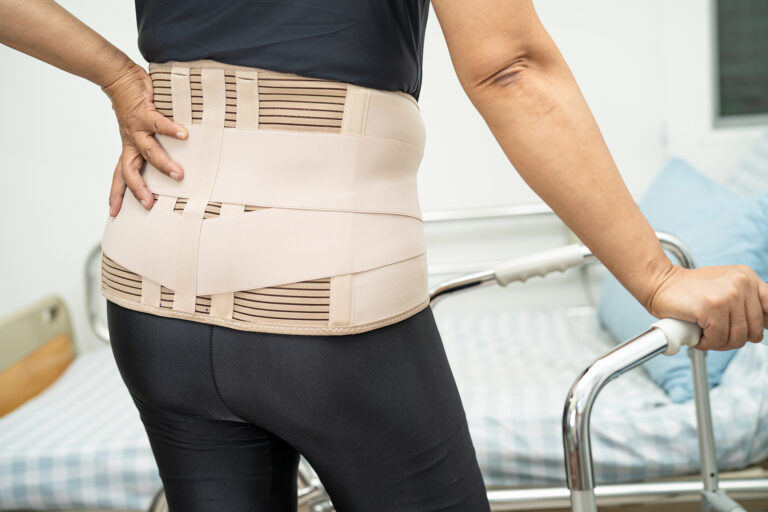 lady patient wearing back pain support belt for orthopedic lumbar with walker.